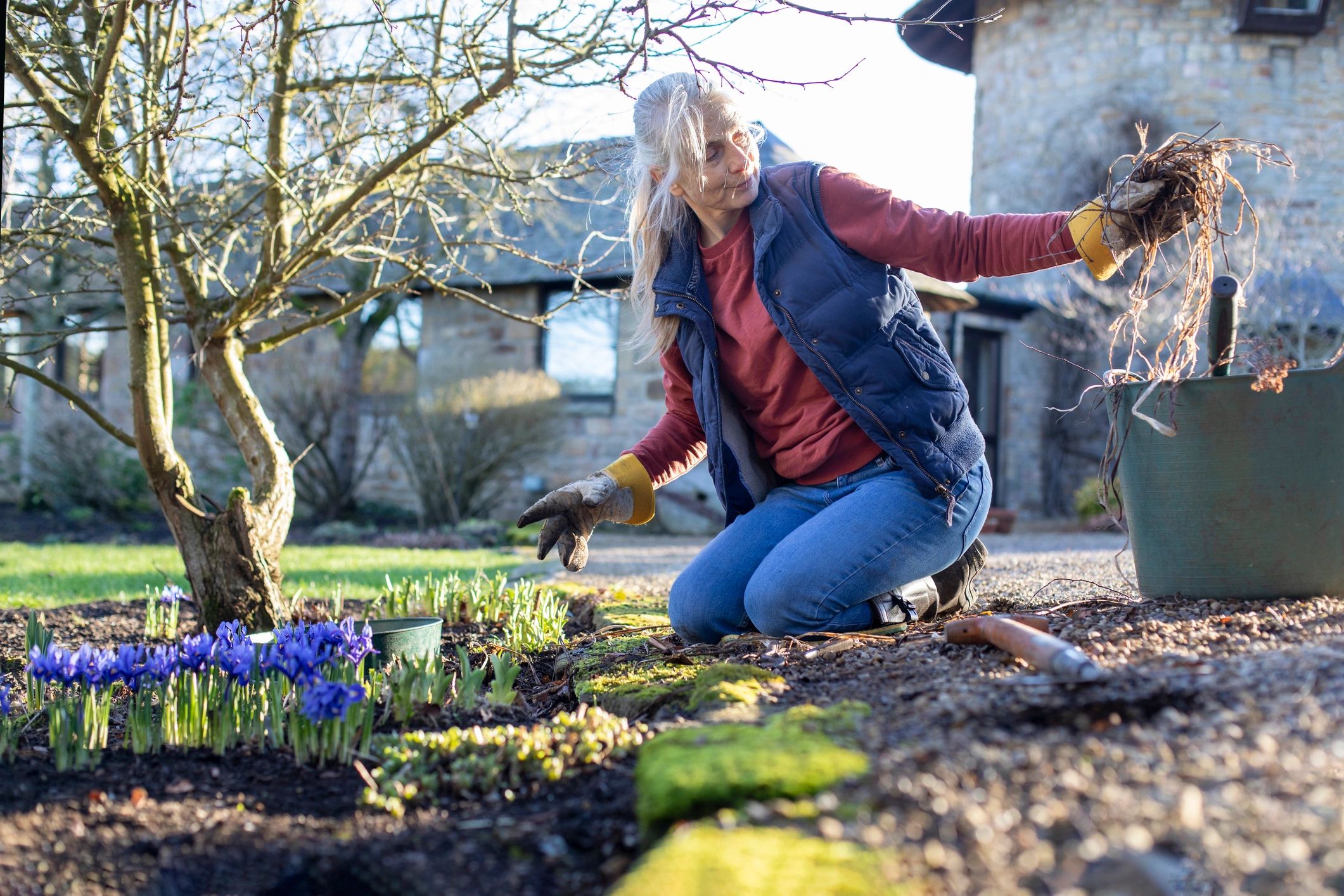 Homeowner planting flowers in a garden bed